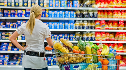 a woman is overwhelmed with the wide range in the supermarket when shopping.