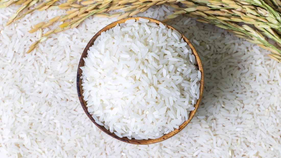 Rice in wooden bowl on rice and  rice ears background, Natural food high in protein.