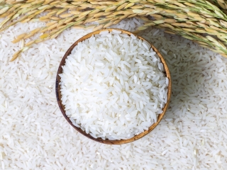 Rice in wooden bowl on rice and  rice ears background, Natural food high in protein.