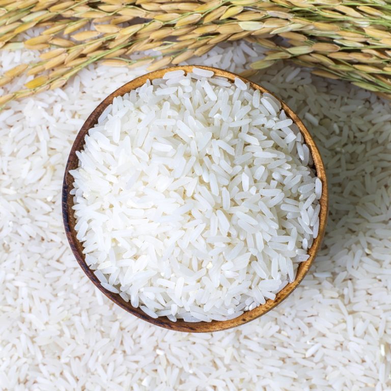 Rice in wooden bowl on rice and  rice ears background, Natural food high in protein.