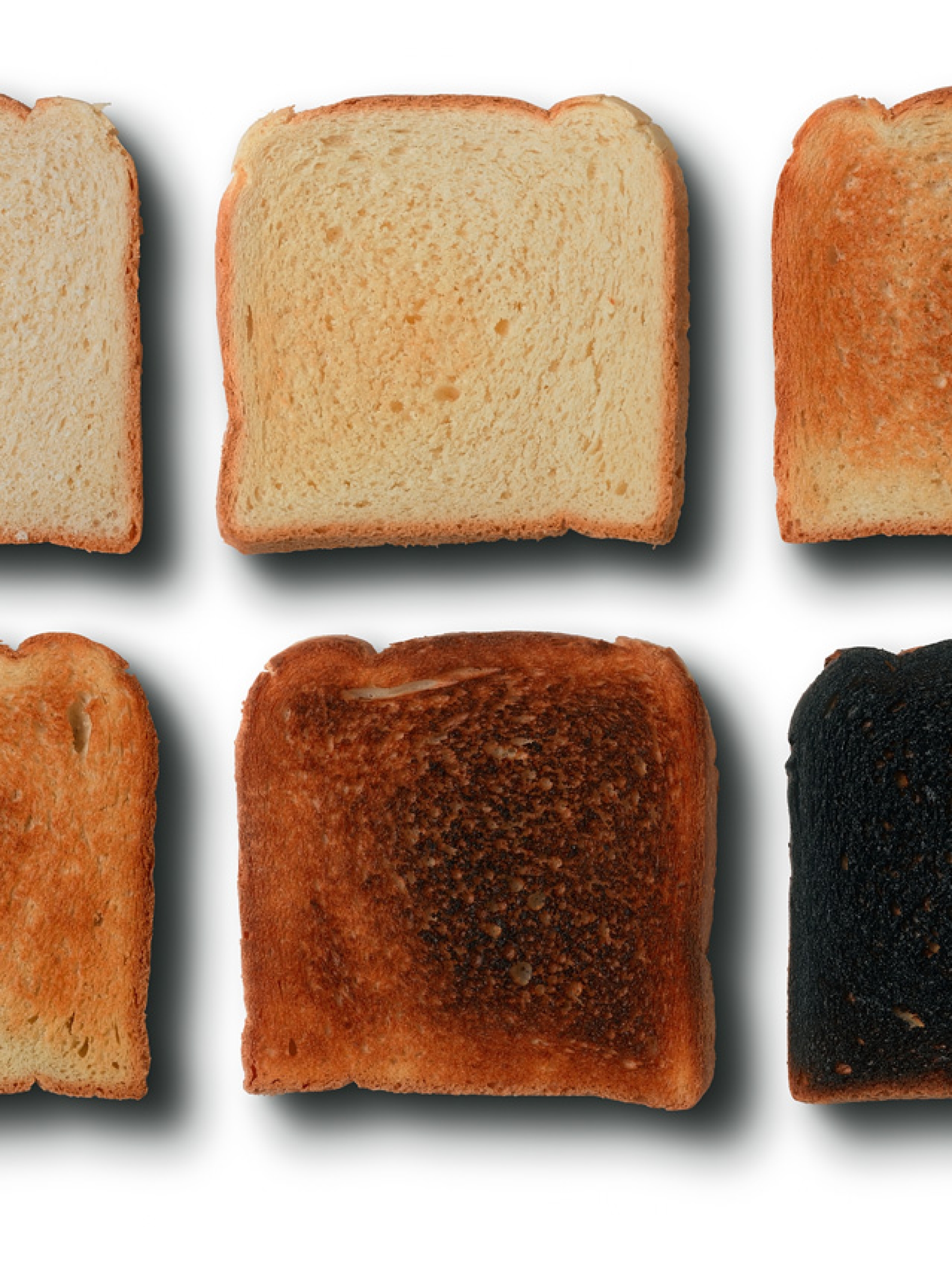 Seis rebanadas de pan con distintos grados de tostado, desde ligeramente doradas hasta quemadas, para representar el aumento de acrilamida durante el calentamiento.