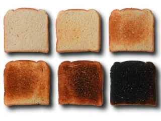 Seis rebanadas de pan con distintos grados de tostado, desde ligeramente doradas hasta quemadas, para representar el aumento de acrilamida durante el calentamiento.