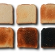 Seis rebanadas de pan con distintos grados de tostado, desde ligeramente doradas hasta quemadas, para representar el aumento de acrilamida durante el calentamiento.